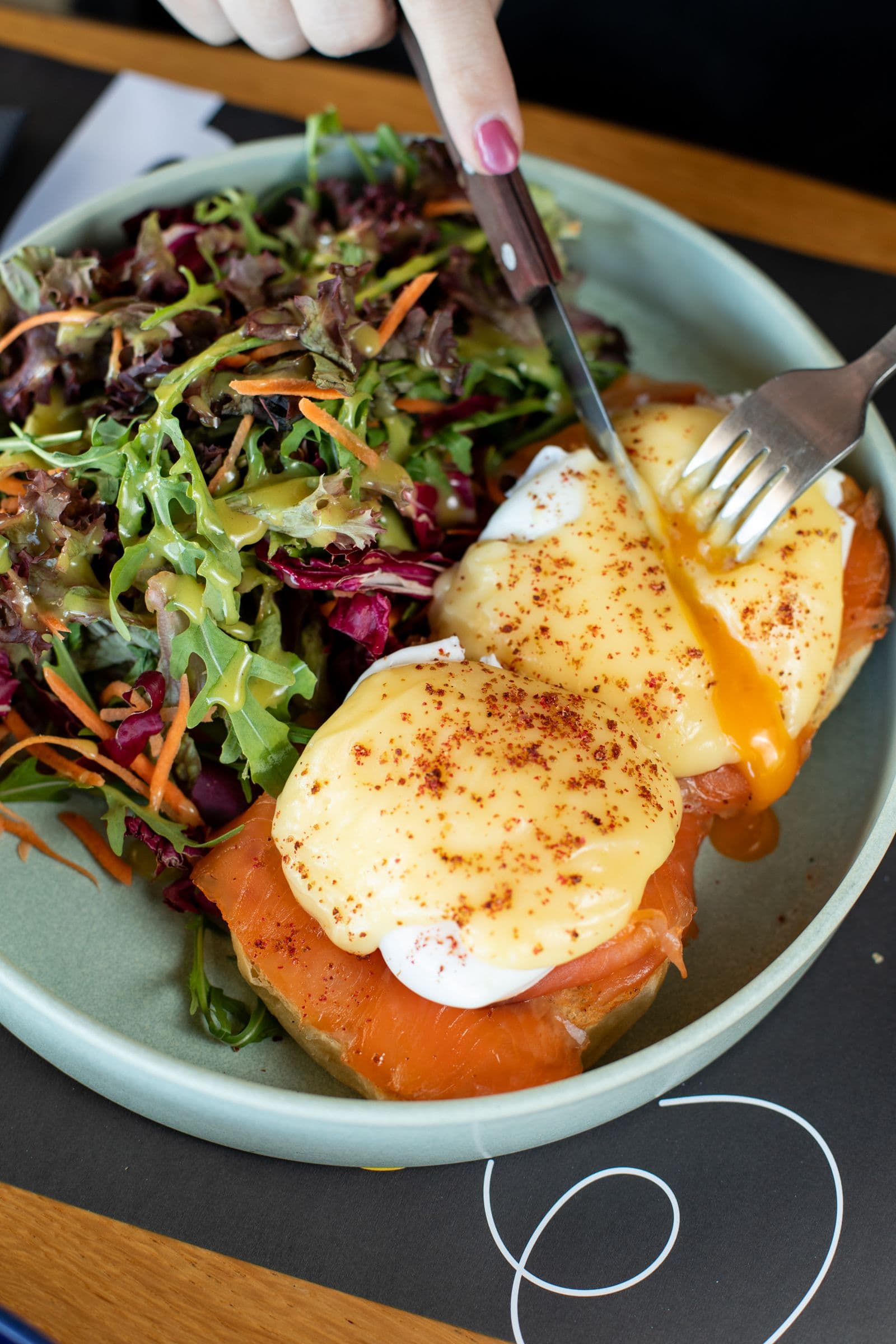 El Burro Benedict cut open, the yolk running over the smoked salmon