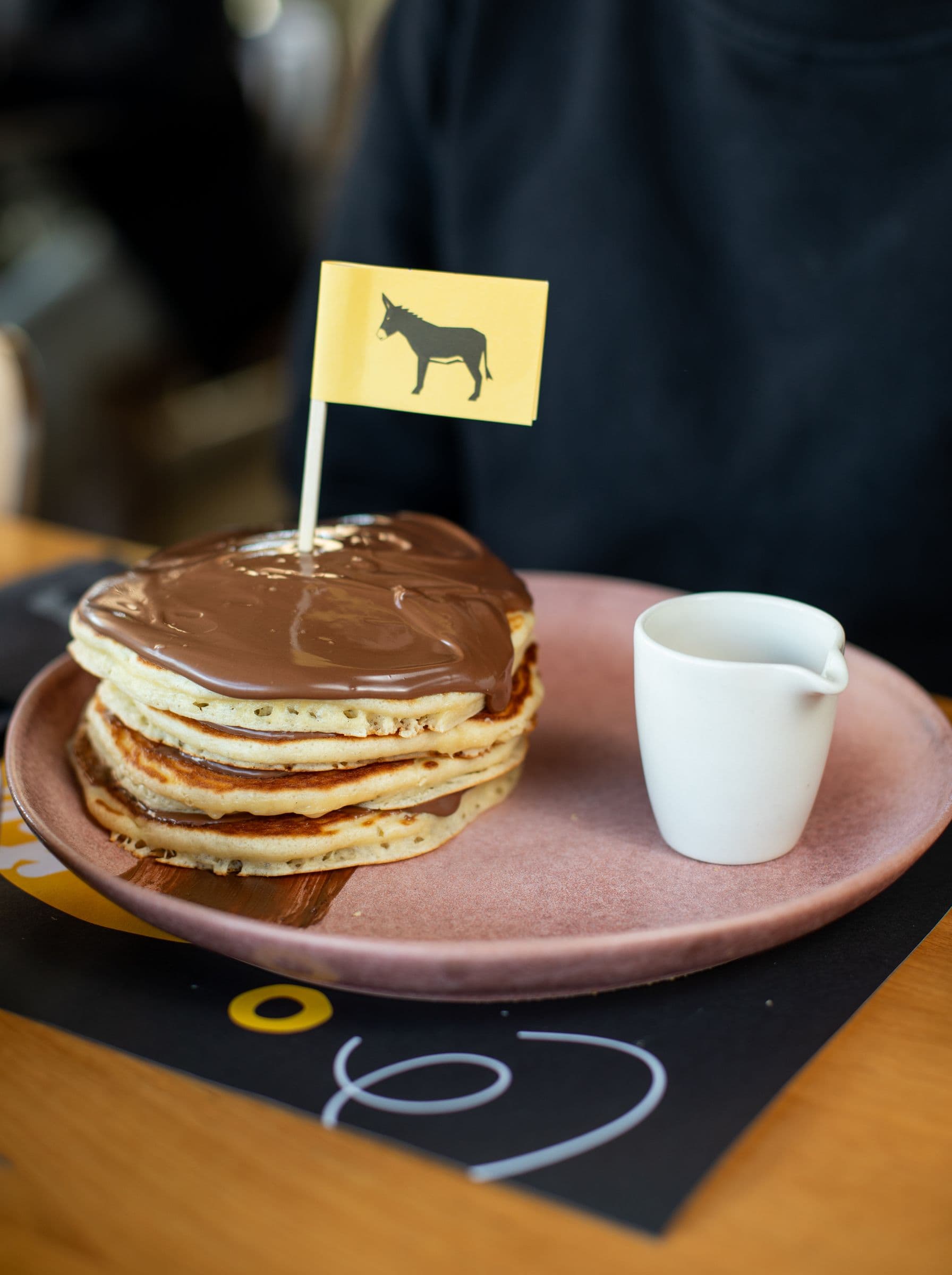 Homemade pancakes with chocolate praline and a yellow donkey flag
