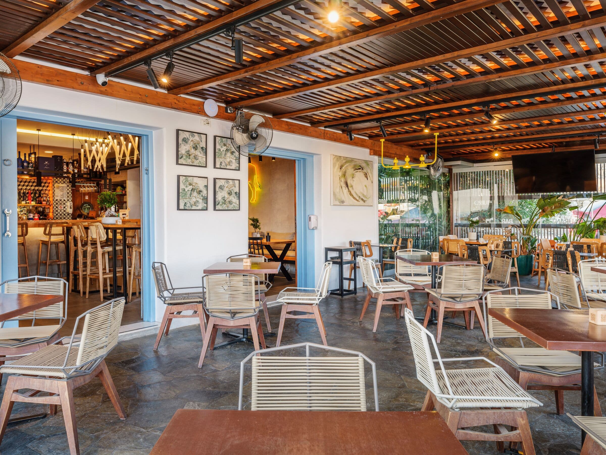 The covered courtyard: rattan chairs and wooden tables under the pergola
